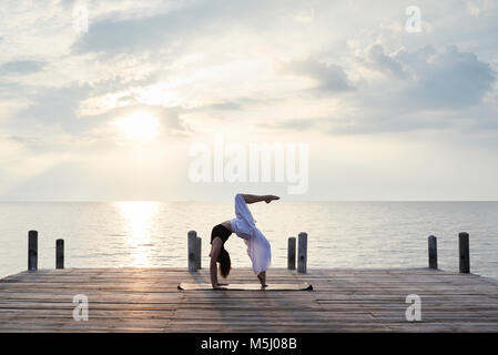 Yoga Lehrer Yoga gegen den Sonnenuntergang und das Meer. Kep, Kambodscha. Stockfoto