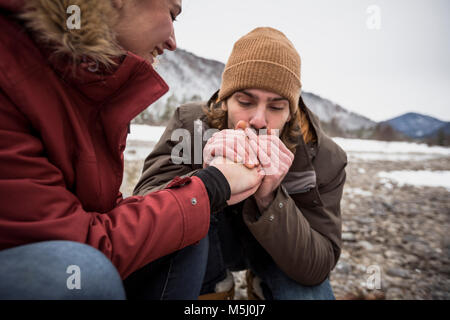 Paar auf eine Reise im Winter mit man wärmende Hände von Frau Stockfoto