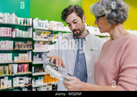 Apotheker beraten Kunden mit sclaes in der Pharmazie Stockfoto