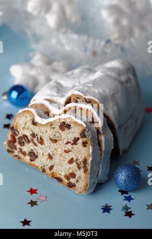 Stollen und Weihnachtsschmuck auf blauem Hintergrund Stockfoto