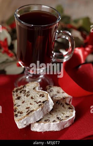 Scheiben von Stollen und Glühwein auf einem rustikalen Tisch Stockfoto