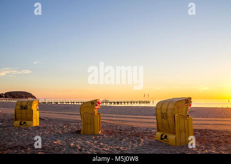 Deutschland, Schleswig-Holstein, Timmendorfer Strand, mit Kapuze liegen am Strand und Seebrücke am Abend Stockfoto