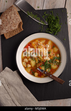 Meatball soup in Emaille Schüssel und Roggen Brot auf einem rustikalen Tisch Stockfoto