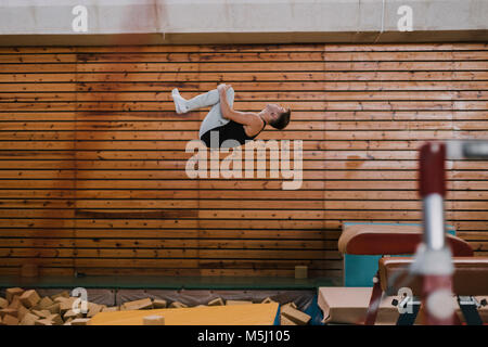 Gymnast ausüben, vaulting Tabelle in der Turnhalle Stockfoto