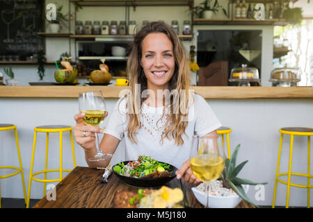 Portrait von lächelnden Frau mit einem Glas Wein in einem Cafe Stockfoto
