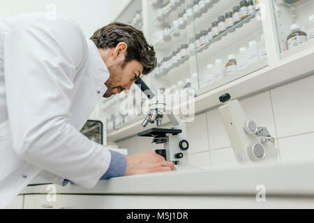 Mann mit Mikroskop im Labor Stockfoto