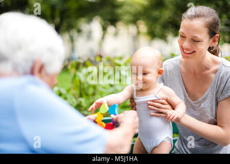 Portrait von lächelnden Mädchen mit Großmutter und Mutter in einem Park Stockfoto