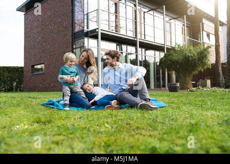 Happy Family auf die Decke im Garten vor ihrem Haus Stockfoto