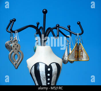 Die bemalte Lady mannequin Schmuck stand mit einer Anzeige der Ohrringe. Stockfoto