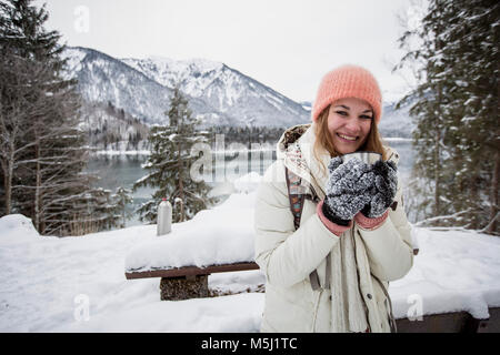 Portrait von lächelnden jungen Frau im Winter Landschaft mit See Stockfoto