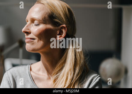 Portrait von lächelnden Gesicht der Frau im Sonnenlicht Stockfoto