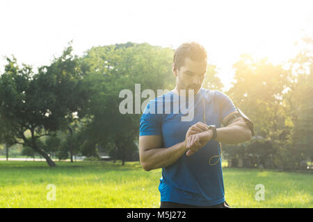 Runner im städtischen Park seinem smartwatch Stockfoto