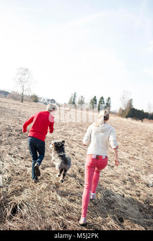 Der Mann und die Frau mit Hund, die auf Feld Stockfoto