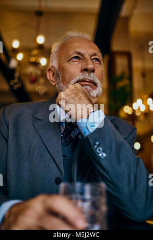 Portrait von eleganten älterer Mann in einer Bar mit Zuhaltung Stockfoto