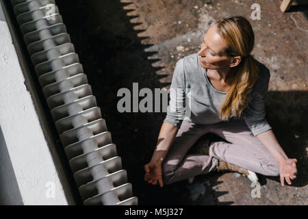 Frau sitzt auf dem Boden üben Yoga Stockfoto