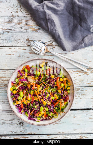 Quinoa Salat mit edamame, Mais, carott, Tomaten, Paprika, Zwiebeln in eine Schüssel geben. Stockfoto