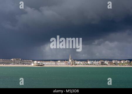Dramatische Regenwolken über Weymouth Strand und Stadt wie aus dem alten Stein Pier gesehen. Stockfoto