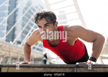 Athleten trainieren Push-ups in der Stadt Stockfoto