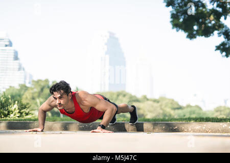 Athleten trainieren Push-ups in der Stadt Stockfoto