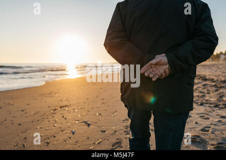 Älterer Mann am Strand flanieren, Rückansicht Stockfoto