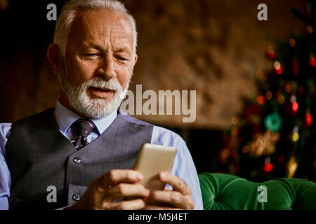 Elegante älterer Mann mit Handy Stockfoto
