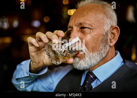 Portrait von eleganten älterer Mann das Trinken aus Becher Stockfoto