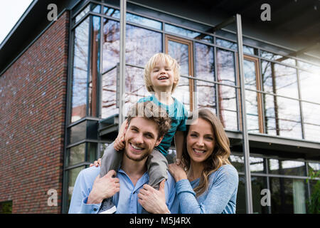 Portrait von lächelnden Eltern mit Sohn vor ihrem Haus Stockfoto