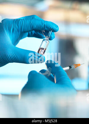 Wissenschaftler halten eine Durchstechflasche mit einer Flüssigkeit im Labor Stockfoto