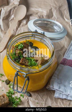 Kürbissuppe mit Croutons, Kürbiskerne, Petersilie in Glas Stockfoto