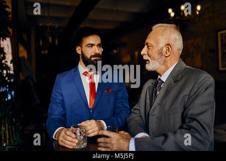 Zwei elegante Männer in einer Bar mit Zuhaltung Stockfoto