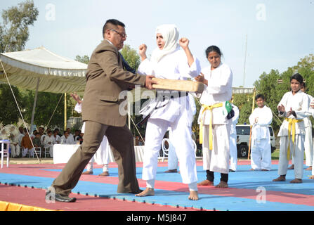 Hyderabad, Pakistan. 23 Feb, 2018. Ein Ausbilder hit bambo auf ein Mädchen Magen bei der Vorstellung des Kyokushin Karate während der nationalen Meisterschaft Credit: Janali Laghari/Pacific Press/Alamy leben Nachrichten Stockfoto