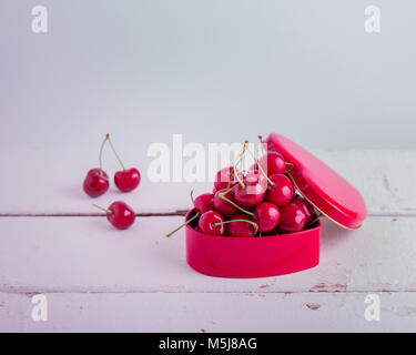 Reifen Kirschen in der Red Box in Herzform, selektive konzentrieren. Stockfoto