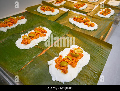 Tamale Vorbereitung mexikanische Rezept mit Bananenblättern und Maismehl Stockfoto