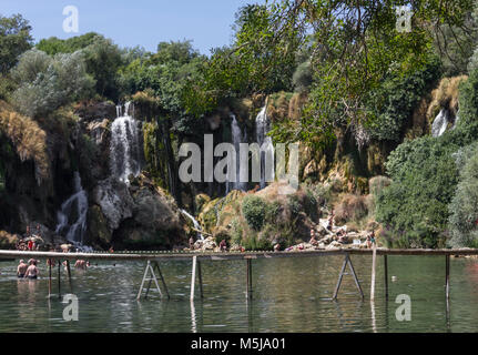 Sind STUDENCI, BOSNIEN UND HERZEGOWINA - 16. AUGUST 2017: Kravice Wasserfällen in Bosnien Herzegowina, mit einem schwimmenden Holzbrücke Stockfoto