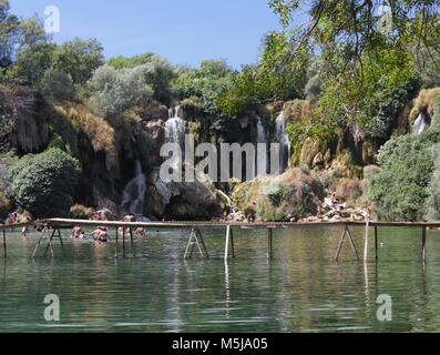 Sind STUDENCI, BOSNIEN UND HERZEGOWINA - 16. AUGUST 2017: Kravice Wasserfällen in Bosnien Herzegowina, mit einem schwimmenden Holzbrücke Stockfoto