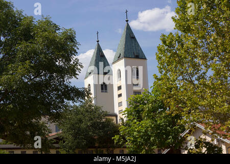 MEDJUGORJE - BOSNIEN UND HERZEGOWINA - 16. AUGUST 2017: Saint James Glockentürme in Medjugorje, von der Natur im Sommer umgeben Stockfoto