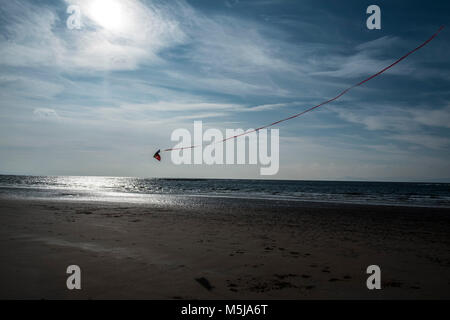 Einen Drachen über dem Strand von Seamill in Ayrshire, Scotlands, UK fliegen. Stockfoto