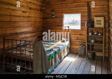 Vintage Holzfäller Cabin Interior - Bett, Regal, und Küchengeräte Stockfoto