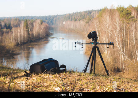 Die Kamera steht auf einem Stativ am Morgen Wald Flusslandschaft, die Feder im Ural Stockfoto