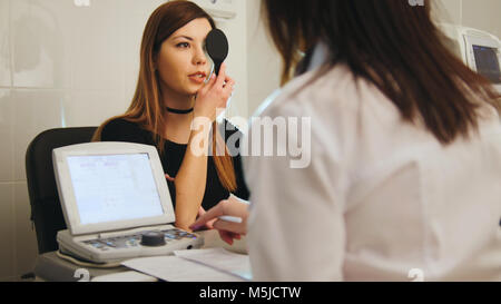 Junge Frau, Auge Test mit Optometriker in Medical Center Stockfoto