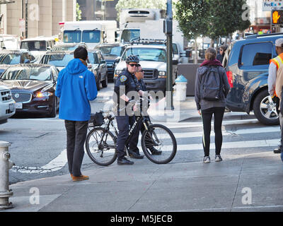 Zwei San Francisco Police Department Officers (eine auf einem Fahrrad) auf einer Straße, Februar 2018 Stockfoto