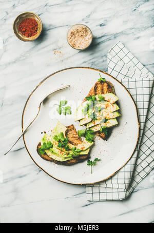 Flachbild-lay von Avocado Toast mit Gewürz Stockfoto