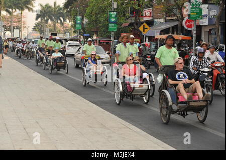 Ökotourismus, Touristen fahren in Cyclos / Fahrrad Rikschas den Sisowath Quay Boulevard am Fluss hinunter. Phnom Penh, Kambodscha. Kredit: Kraig lieb Stockfoto