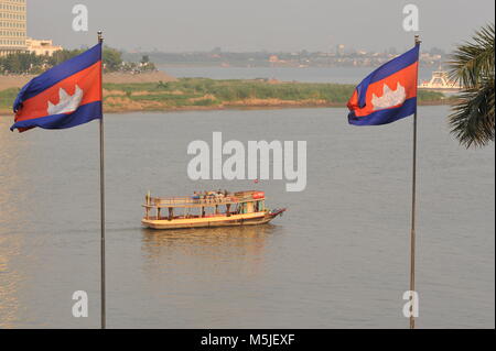 Riverboat auf dem Tonle Sap Fluss führt in zwischen 2 kambodschanischen Fahnen in der Nähe des Zusammenfluss von Mekong und Tonle Sap Fluss. Credit: Kraig Lieb Stockfoto