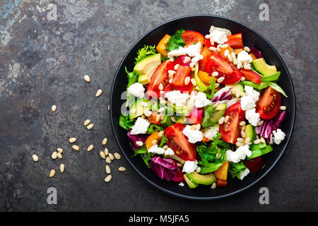Gemüse, Salat mit Avocado, Paprika, Tomaten, italienische Mischung, frischem Salat, Feta Käse und Pinienkernen. Gesundes Essen. Ansicht von oben Stockfoto