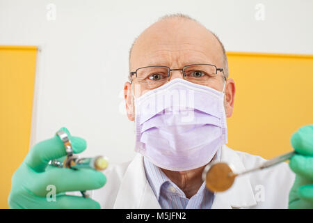 In der Nähe Bild von älteren männlichen Zahnarzt Holding zahnmedizinische Instrumente - anesthesic Spritze und Spiegel Stockfoto