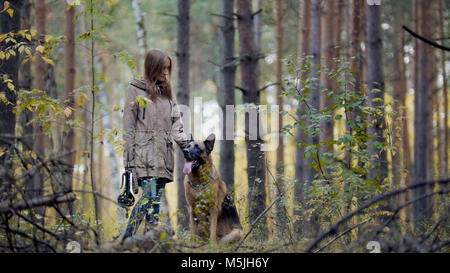 Junges attraktives Mädchen und ihr Haustier - Deutscher Schäferhund - zu Fuß auf einem Herbst Wald Stockfoto