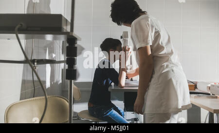 Frau optometrist Prüfung vor der heranwachsenden jungen Augen in der Augenheilkunde Klinik Stockfoto