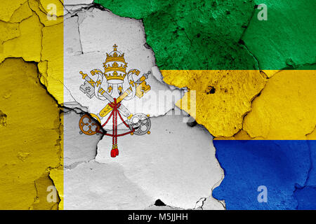 Flagge von Vatikan und Gabun auf gerissene Wand gemalt Stockfoto