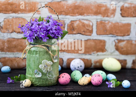 Ostern Dekoration mit violetten Blüten und bemalte Eier Stockfoto